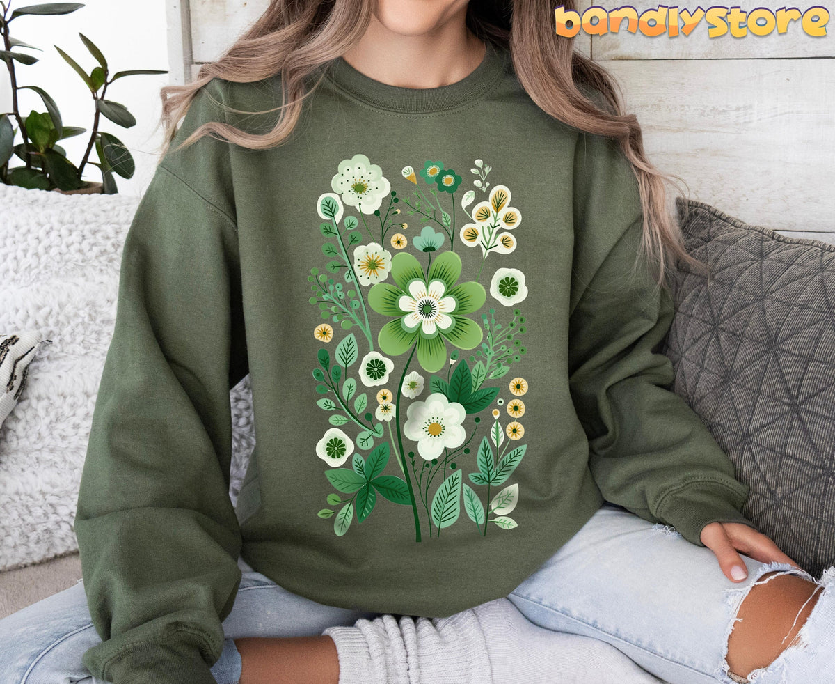 Scandinavian Wildflowers Sweatshirt in military green front view on seated person with pillows, plant, wood wall.