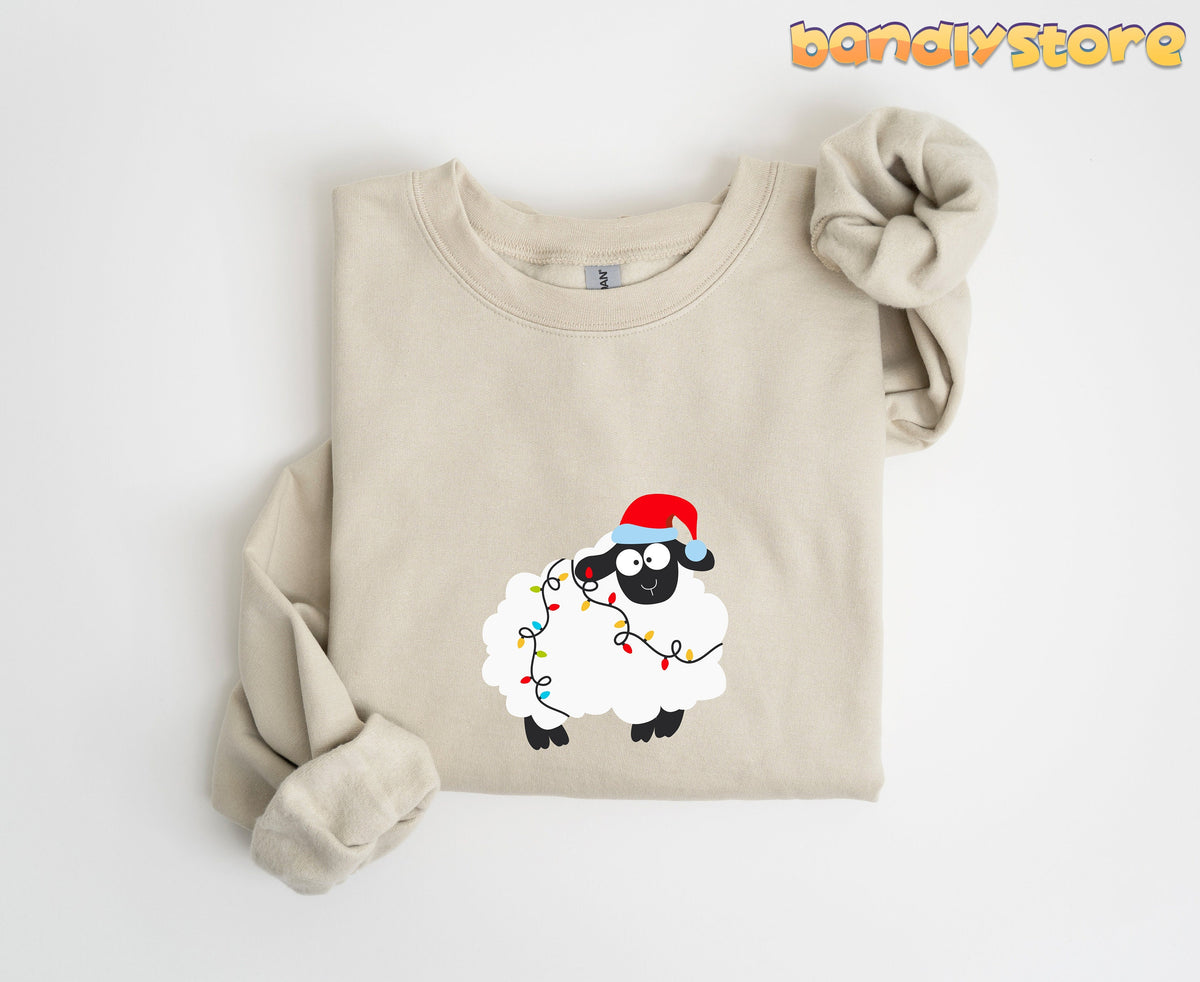 Sheep Christmas Lights Sweatshirt in Sand, folded flat on white with sleeves knotted, cartoon sheep in Santa hat and lights.