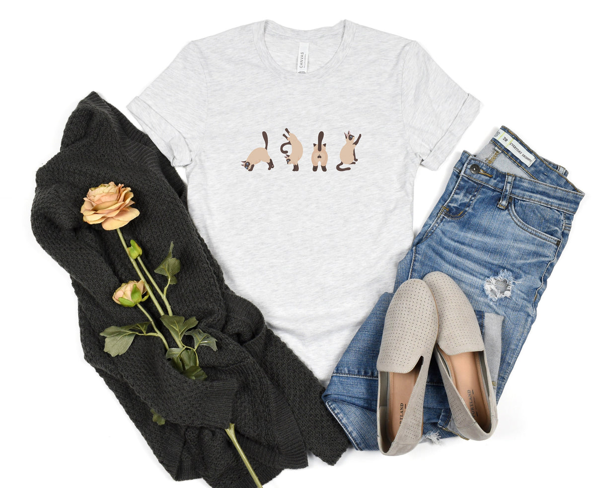 Siamese Cat T-Shirt in ash flat-laid beside knitwear, roses, jeans and loafers.