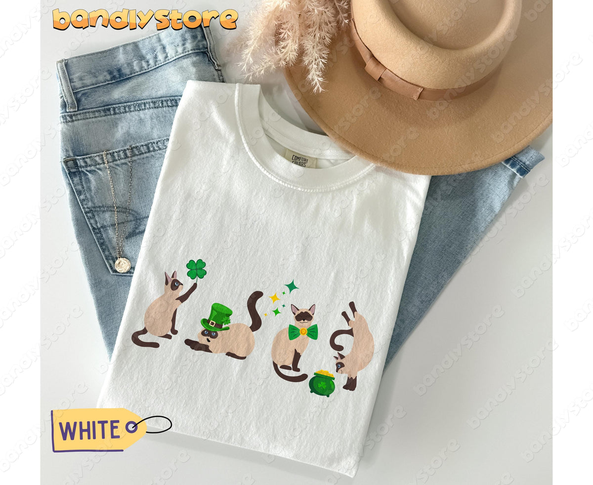 Siamese Cat Shamrock T-Shirt in white flat-laid beside jeans, hat, necklace and pampas grass.