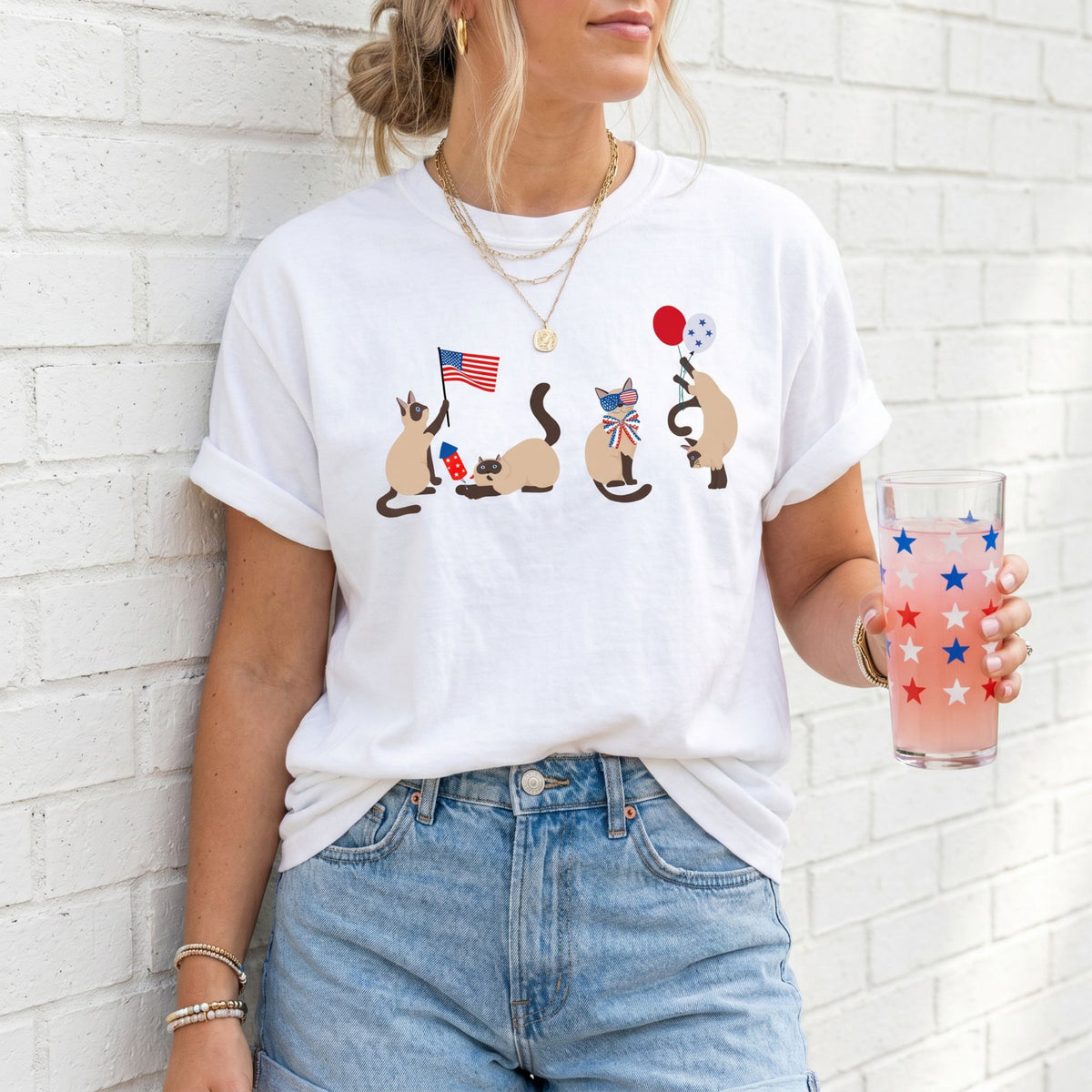 Siamese Cats 4th of July T-Shirt white on woman against brick wall holding starred glass