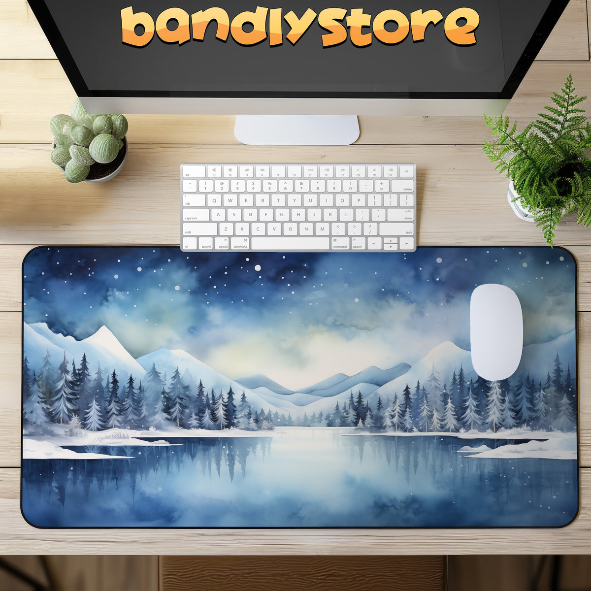 Snow Mountains Desk Mat on a wooden desk in overhead view with keyboard, mouse, monitor and plants.