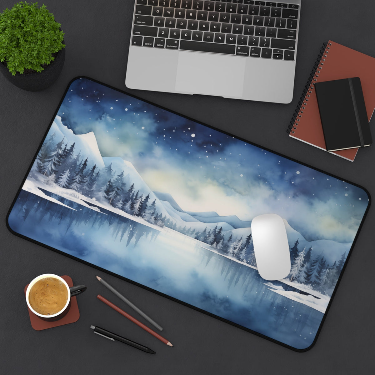 Snow Mountains Desk Mat in overhead view on a desk with laptop, plant, notebooks, coffee, pens and mouse, 12 × 22 inches.
