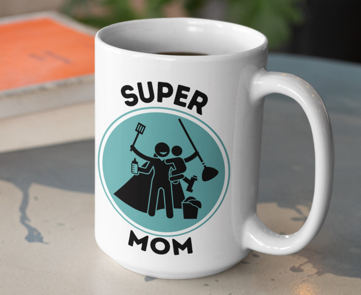 Supermom Mug on a speckled table, angled right, teal circle with black mom-and-child graphic, books and plant behind.