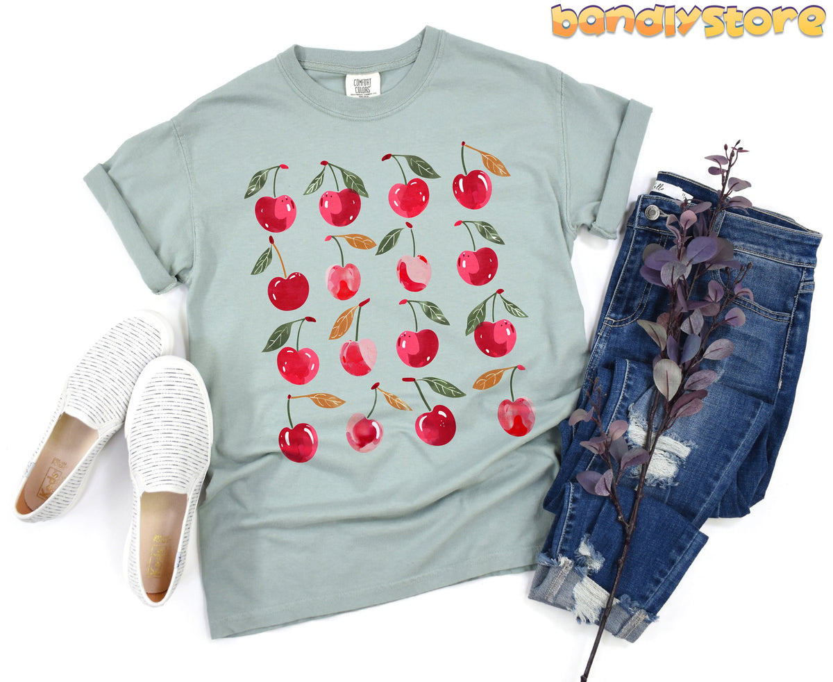 Sweet Cherry T-Shirt in Bay, flat lay with white slip-ons, blue jeans and purple foliage.