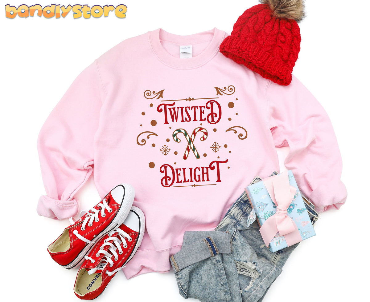 Twisted Delight Candy Cane Sweatshirt in light pink flat-laid from above beside red beanie, sneakers, jeans and gift.