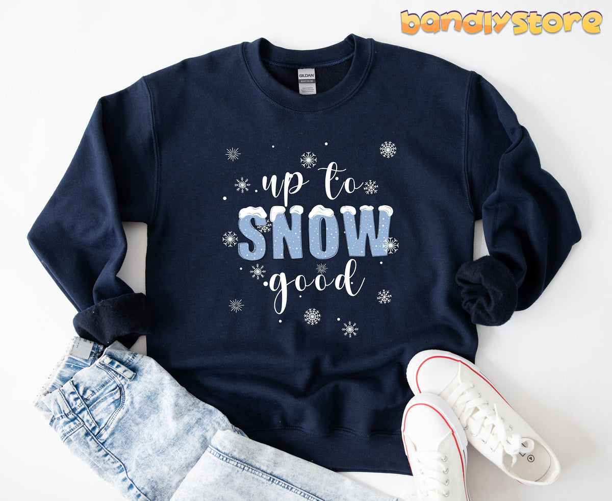 Up To Snow Good Sweatshirt in navy laid flat on white with jeans and sneakers beside it.