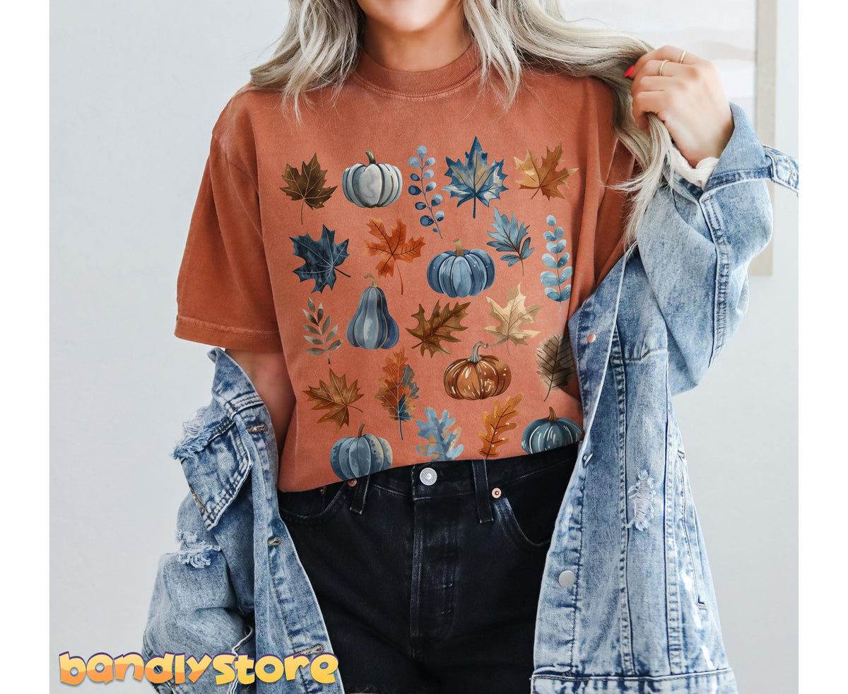 Vintage Fall Leaves T-Shirt in yam on a model holding a denim jacket over black jeans by a plain wall.