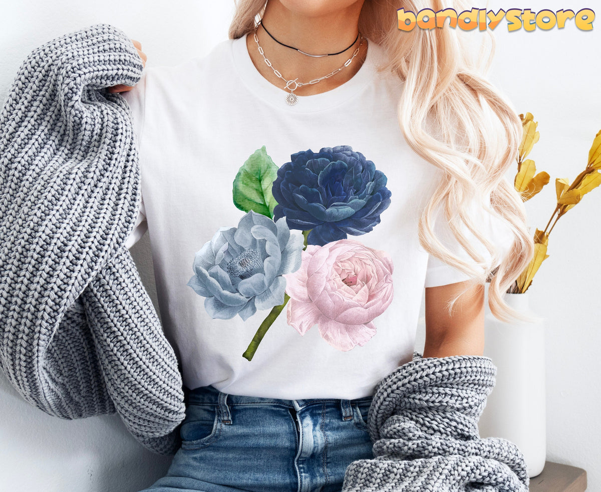 Vintage Rose Flowers T-Shirt in white, shown from the front on a person holding a grey sweater next to a vase.