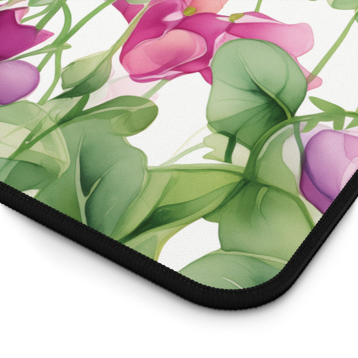 Watercolor Sweet Pea Flowers Desk Mat detail of black-stitched corner with floral print on white.
