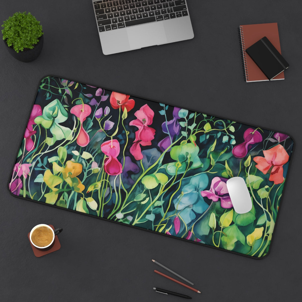 Watercolor Sweet Pea Flowers Desk Mat, 16 × 32 inches, viewed from above on a desk with laptop, plant, cup and pens.